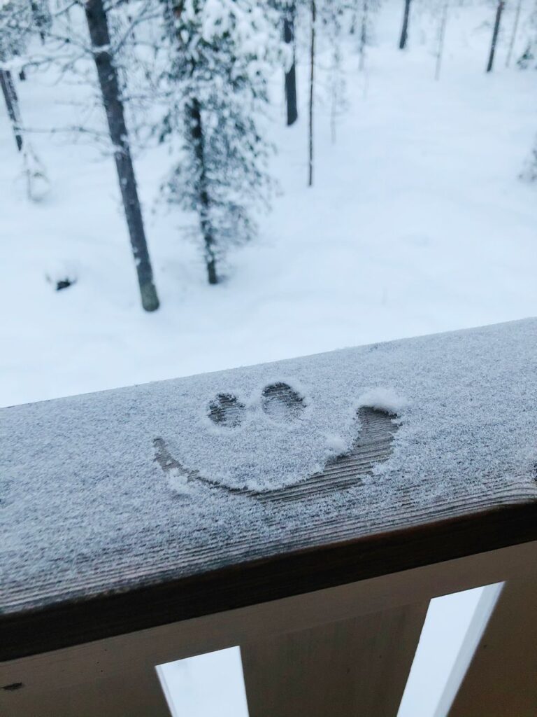 snowy smiley face on winter balcony